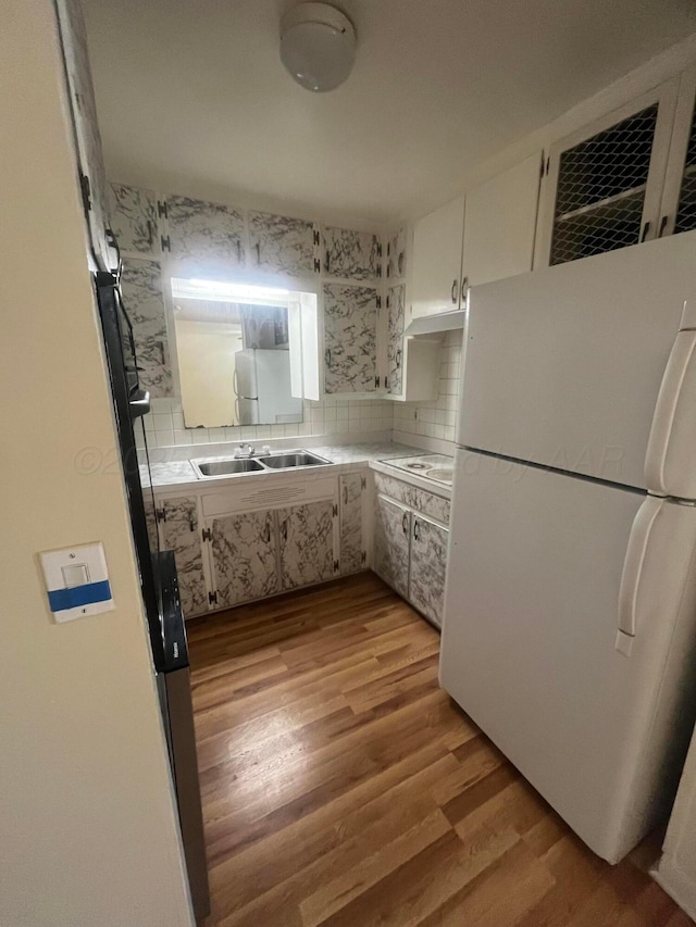 1565 Bell St, Amarillo, TX 79106 - kitchen with freestanding refrigerator, light wood-style floors, a sink, and light countertops