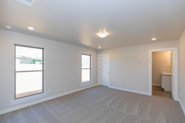 empty room with recessed lighting, light colored carpet, visible vents, and baseboards