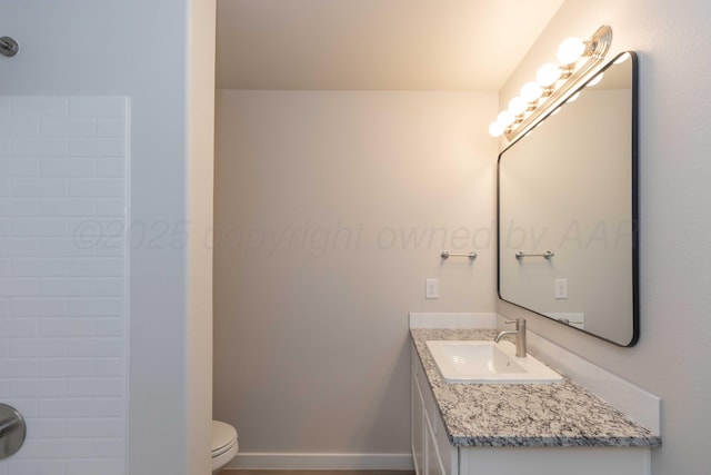 bathroom with toilet, baseboards, and vanity