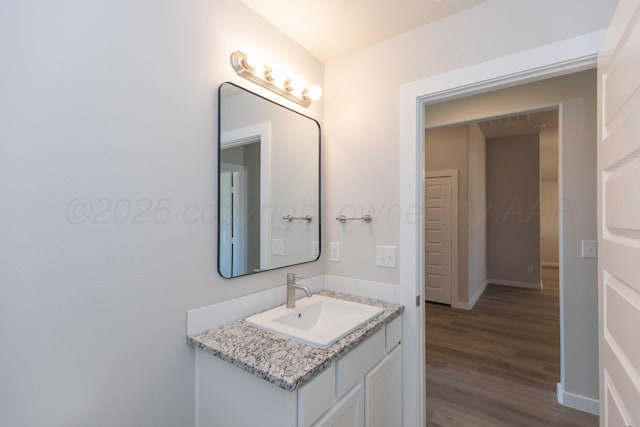 bathroom featuring wood finished floors, vanity, and baseboards