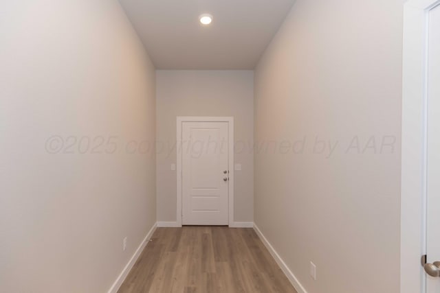 hallway with light wood-type flooring and baseboards