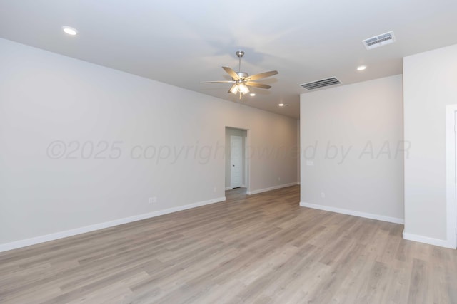 unfurnished room featuring light wood-style flooring, visible vents, and baseboards