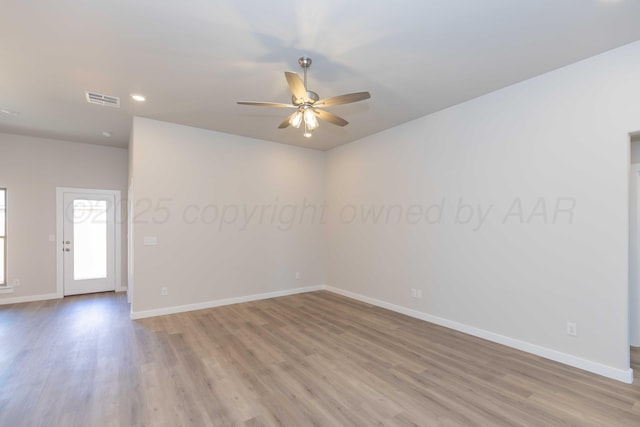 unfurnished room featuring light wood-style floors, visible vents, baseboards, and a ceiling fan