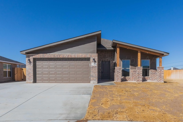 view of front of house featuring a garage, concrete driveway, and brick siding