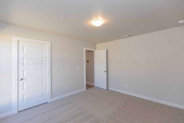 carpeted empty room featuring baseboards and visible vents