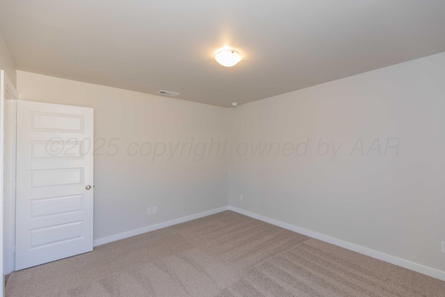 spare room featuring carpet, visible vents, and baseboards