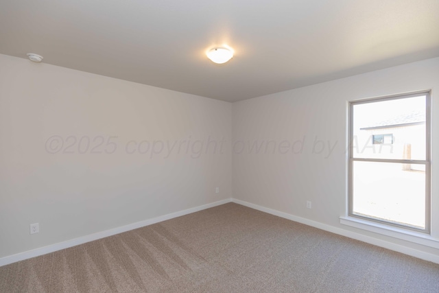 carpeted empty room featuring plenty of natural light and baseboards