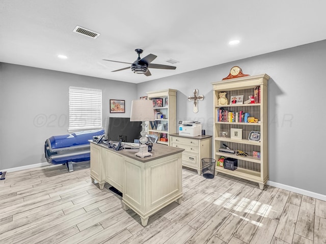 office space featuring visible vents, ceiling fan, baseboards, and light wood-style floors