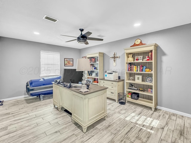 office area with baseboards, a ceiling fan, and light wood finished floors