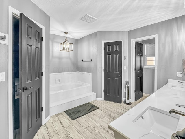 full bath with wood finish floors, a bath, visible vents, and a sink