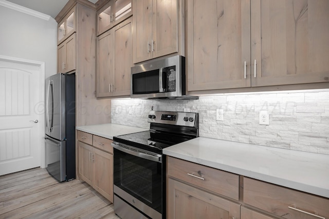 kitchen with decorative backsplash, ornamental molding, appliances with stainless steel finishes, glass insert cabinets, and light wood-style floors