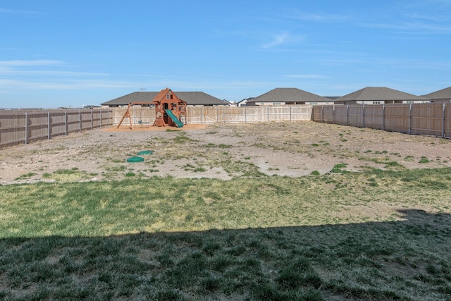 view of yard with a fenced backyard and a playground
