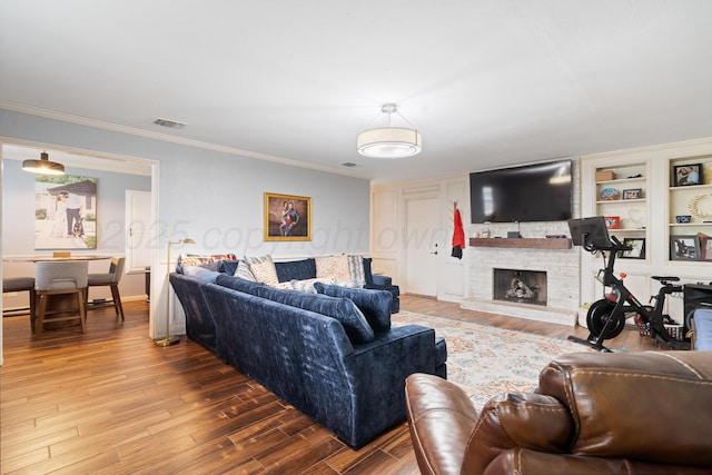 3313 Burrus Pl, Amarillo, TX 79121 - living area featuring wood finished floors, ornamental molding, and a stone fireplace