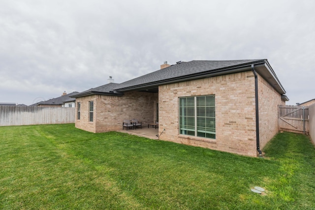 back of property featuring brick siding, a chimney, a patio, and a shingled roof