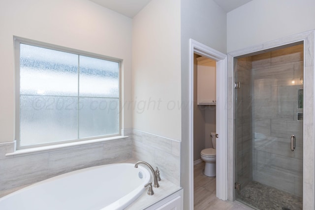 full bathroom with a bath, a shower stall, and toilet