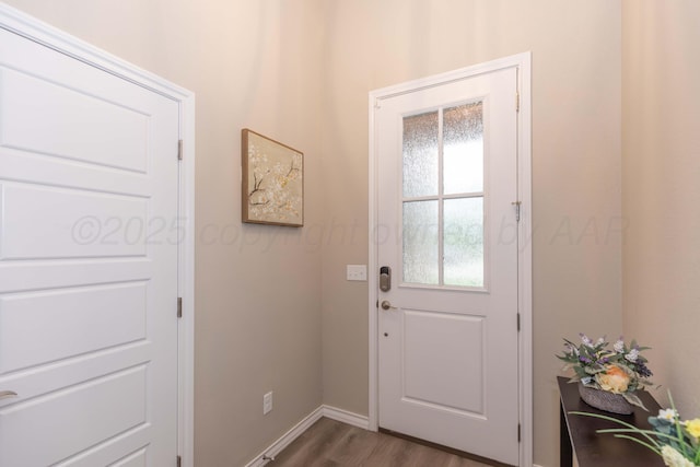 doorway with dark wood-type flooring and baseboards