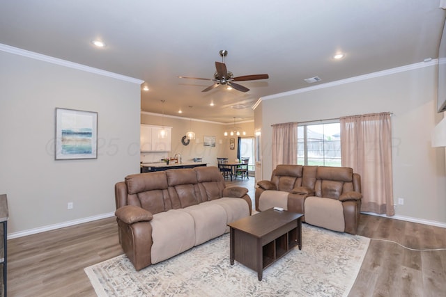 living area featuring ceiling fan, light wood-style flooring, baseboards, recessed lighting, and ornamental molding