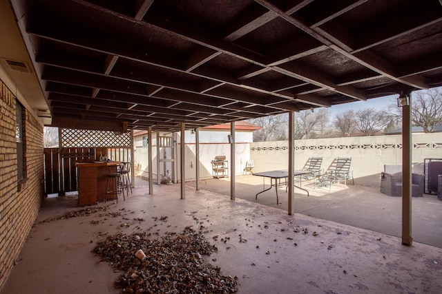 view of patio with visible vents, outdoor dry bar, and fence