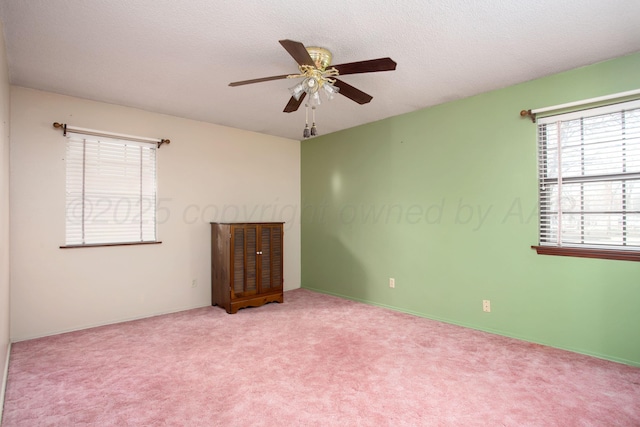 carpeted empty room with a textured ceiling and ceiling fan