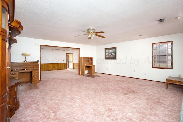 carpeted living room with visible vents, a textured ceiling, and a ceiling fan