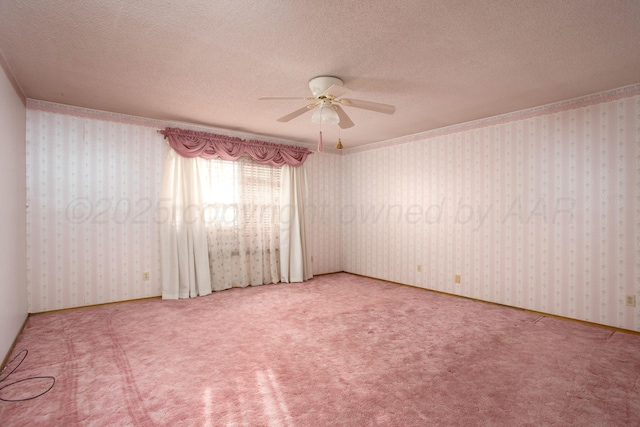 spare room with wallpapered walls, ceiling fan, carpet floors, and a textured ceiling