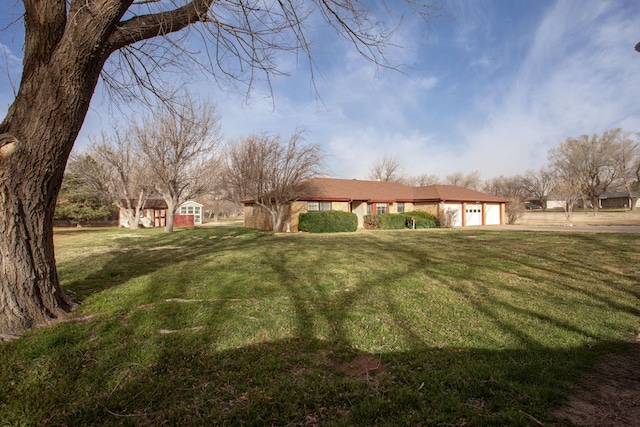 view of yard featuring a garage and driveway