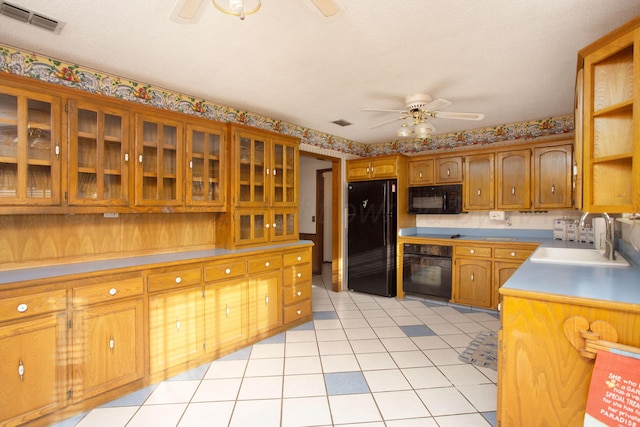 kitchen with visible vents, black appliances, a sink, brown cabinetry, and ceiling fan