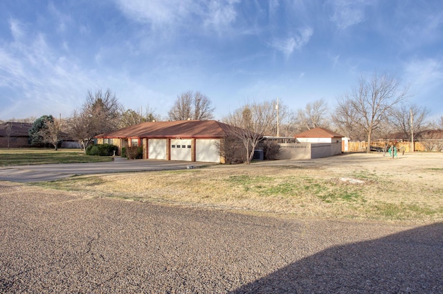 view of front of house with aphalt driveway and fence