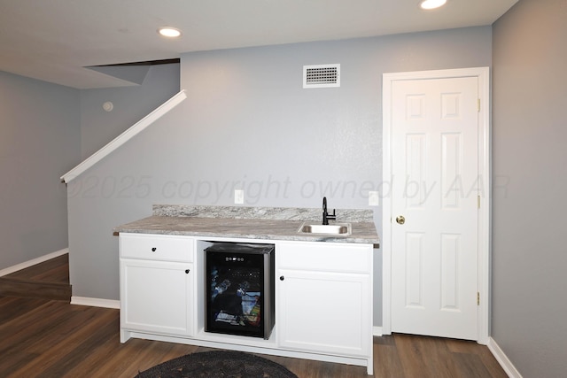 indoor wet bar with wine cooler, dark wood-type flooring, baseboards, and recessed lighting