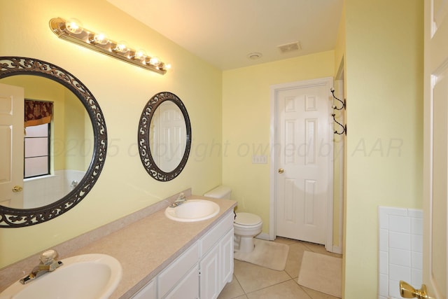 bathroom with tile patterned flooring, toilet, and double vanity
