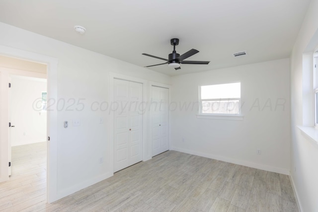 3807 Hancock St, Amarillo, TX 79109 - unfurnished bedroom featuring light wood finished floors, two closets, baseboards, and a ceiling fan
