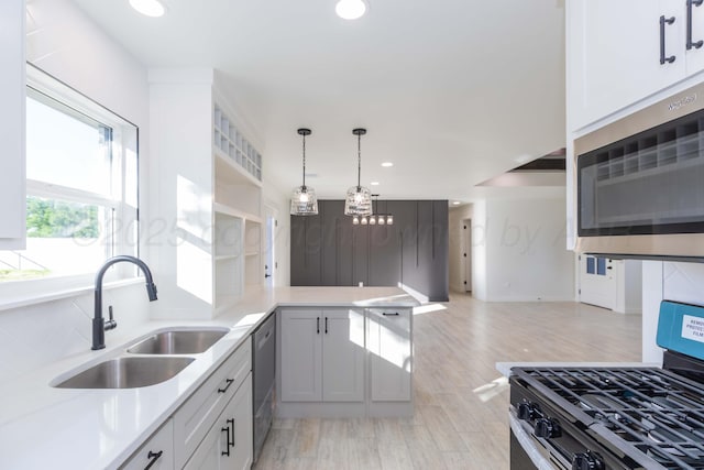 3807 Hancock St, Amarillo, TX 79109 - kitchen featuring stainless steel appliances, a sink, recessed lighting, light countertops, and hanging light fixtures