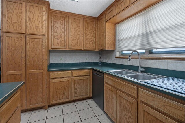 5021 Westway Trl, Amarillo, TX 79109 - kitchen featuring dishwashing machine, a sink, dark countertops, and brown cabinets