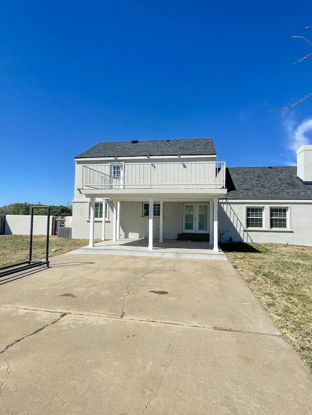 rear view of house with a lawn and cooling unit