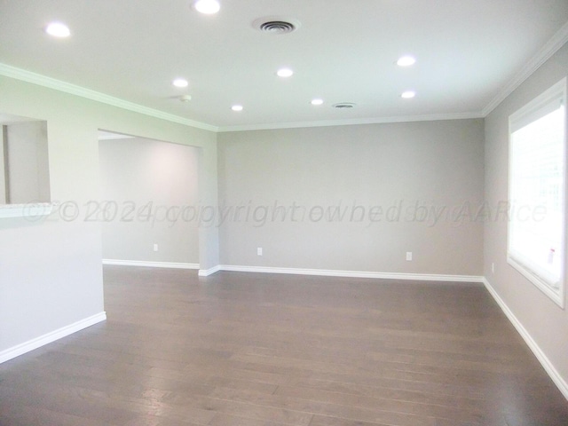 empty room featuring dark hardwood / wood-style flooring and ornamental molding