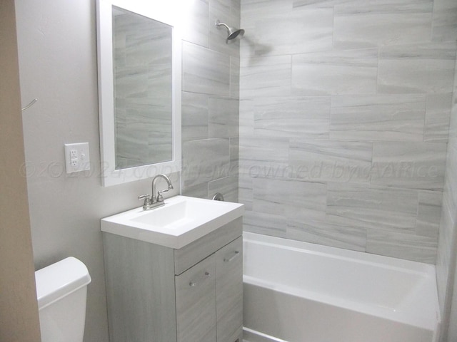 full bathroom featuring vanity, toilet, and tiled shower / bath combo