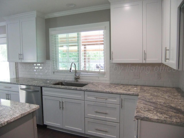 kitchen with light stone counters, backsplash, sink, white cabinets, and stainless steel dishwasher