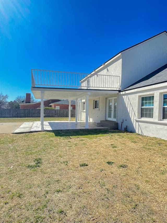 back of house with a patio area and a lawn