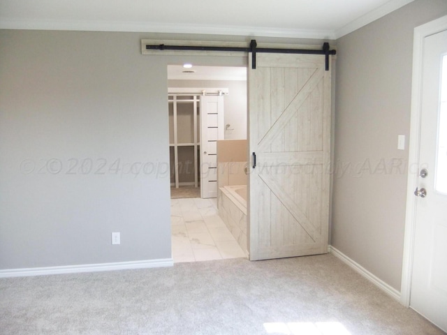 unfurnished bedroom featuring a closet, a spacious closet, ornamental molding, a barn door, and light colored carpet