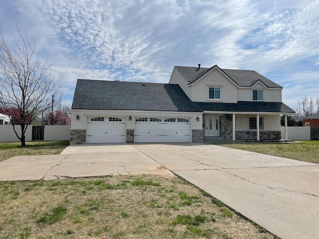 view of front facade with a front yard, covered porch, and a garage