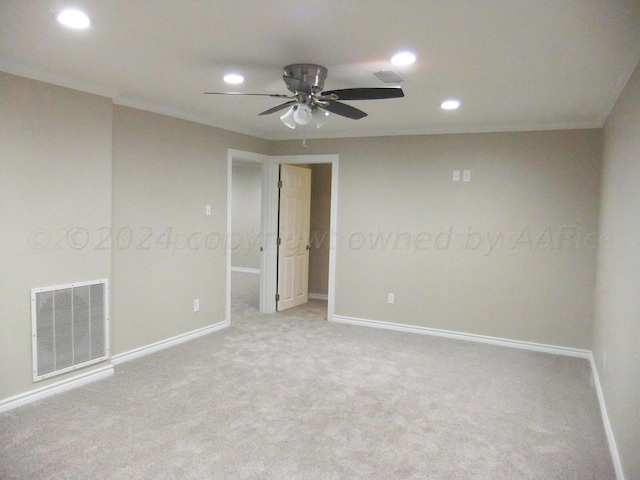 unfurnished room with light colored carpet and ceiling fan