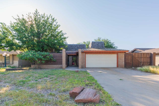 6011 Hatfield Cir, Amarillo, TX 79109 - view of front of house with a garage, brick siding, mansard roof, and concrete driveway