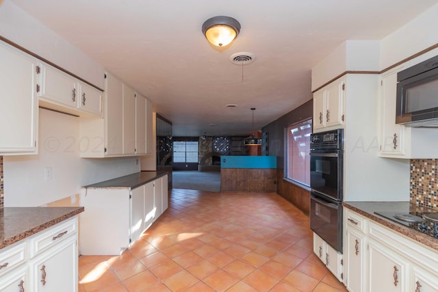 6011 Hatfield Cir, Amarillo, TX 79109 - kitchen featuring black appliances, dark countertops, open floor plan, light tile patterned floors, and white cabinetry