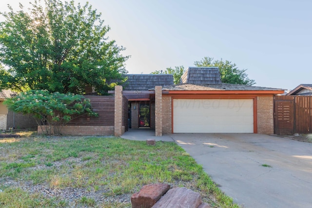 6011 Hatfield Cir, Amarillo, TX 79109 - view of front facade featuring mansard roof, brick siding, a garage, and driveway