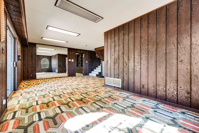 interior space featuring a textured ceiling and wooden walls