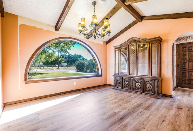 interior space with vaulted ceiling with beams, wood-type flooring, a textured ceiling, and an inviting chandelier