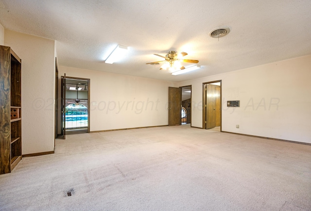 unfurnished room with ceiling fan, light colored carpet, and a textured ceiling