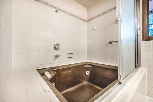 bathroom featuring separate shower and tub and a textured ceiling