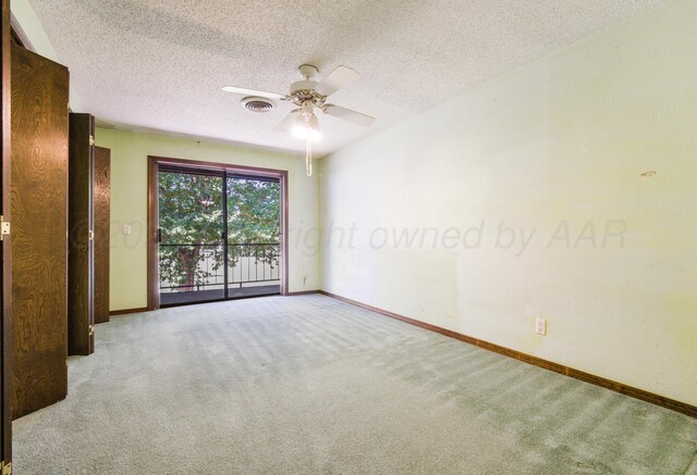 carpeted spare room featuring ceiling fan and a textured ceiling