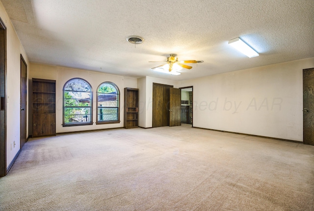 unfurnished room featuring light carpet, a textured ceiling, and ceiling fan